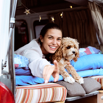 A girl and her dog lie in the back of a Hippie Hitop